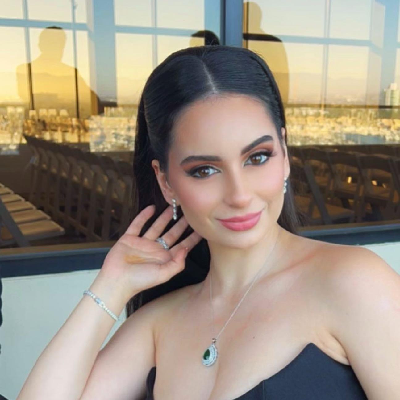 Client in a black strapless dress with defined eyes, sculpted skin, and a pink lip