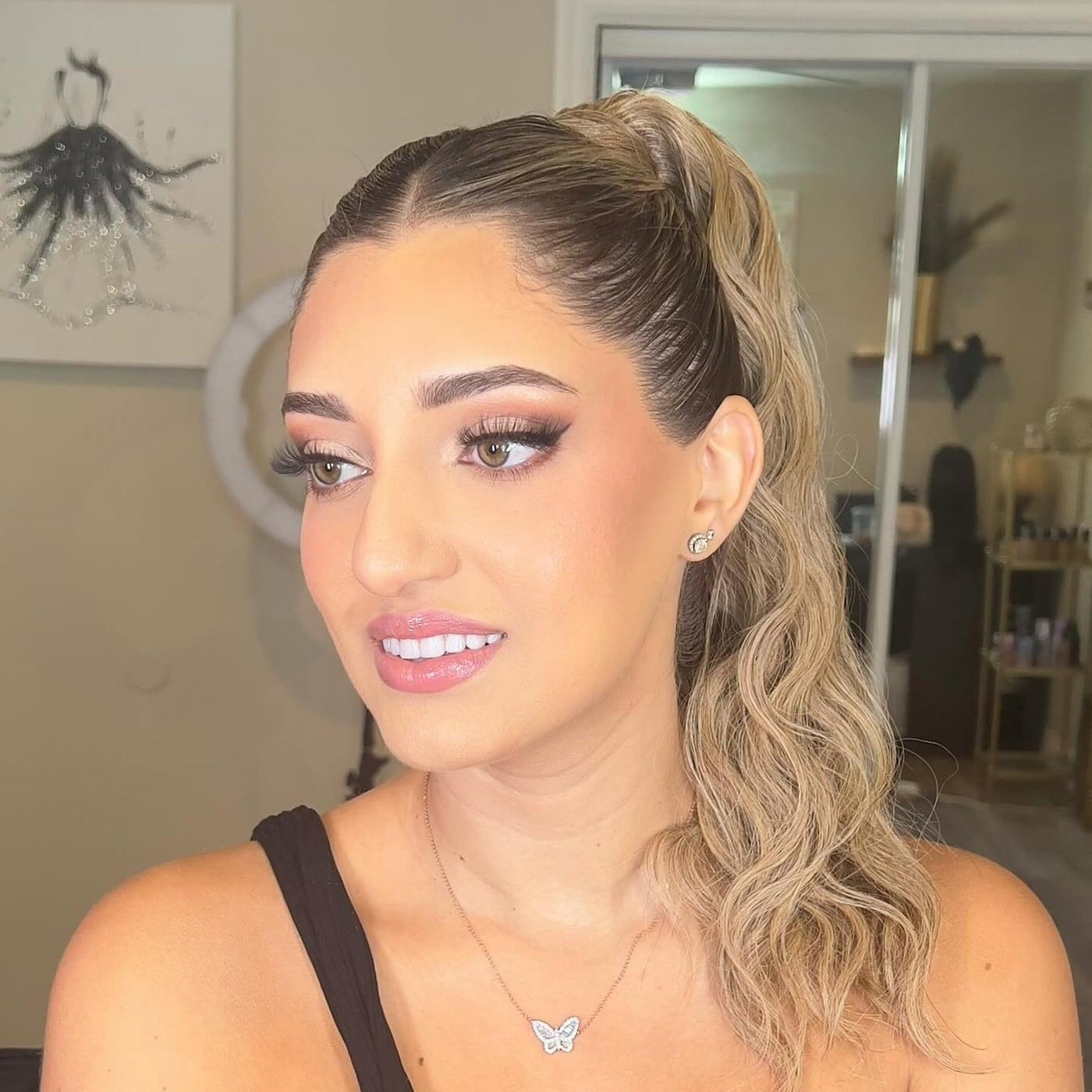 Client with glam makeup, lashes, and a sleek high ponytail