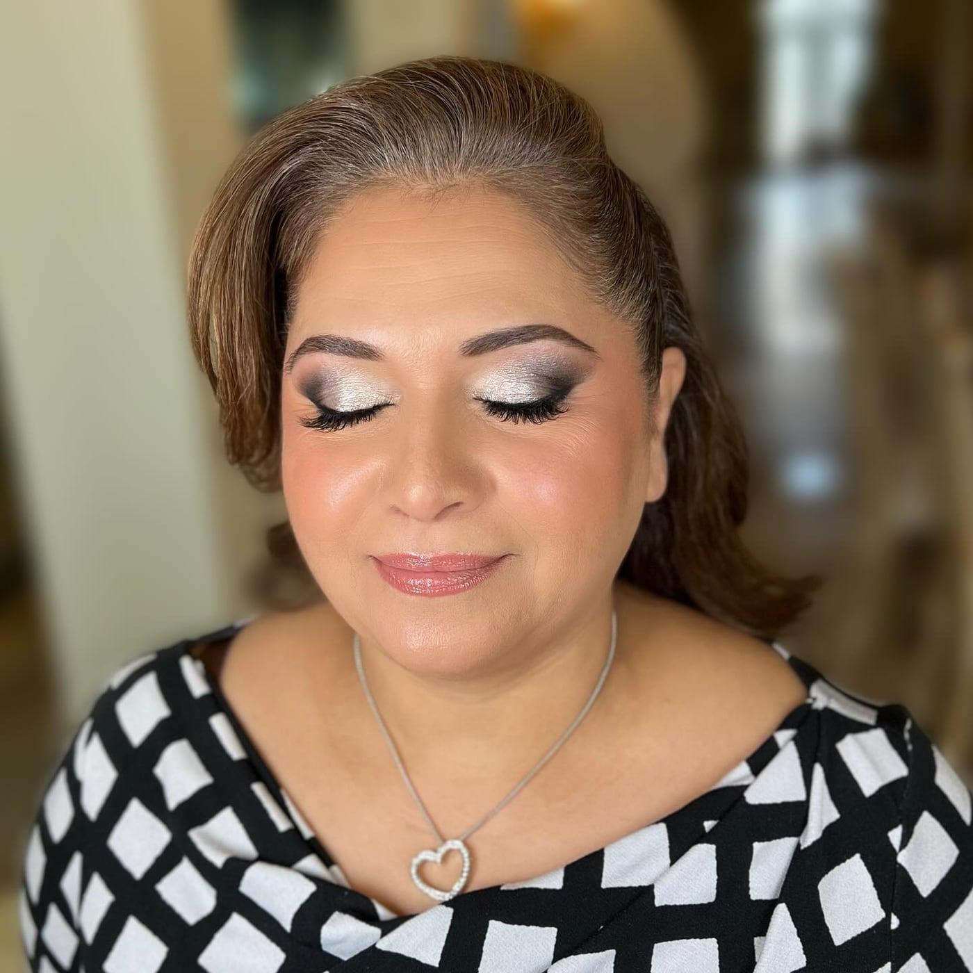 Mature client with silver shimmer eyes, lashes, and a pink lip, eyes closed