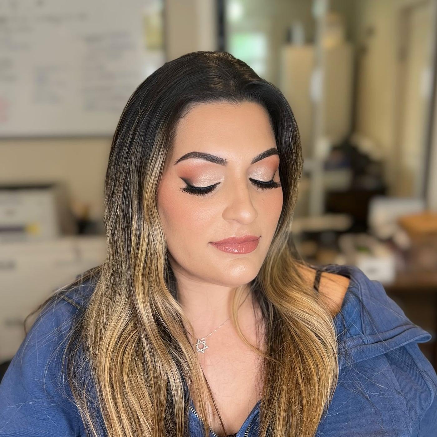 Client with a soft cut crease, lashes, and a nude lip, with highlighted hair