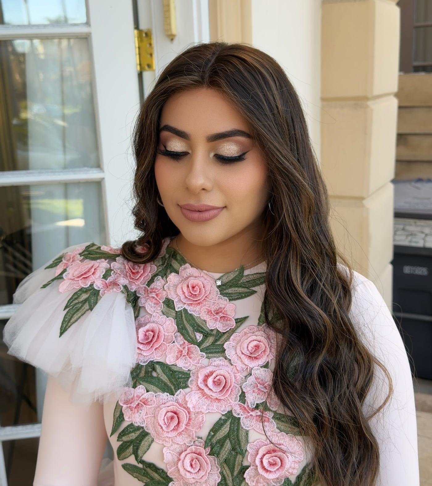 Client with soft glam makeup and long waves in a floral dress