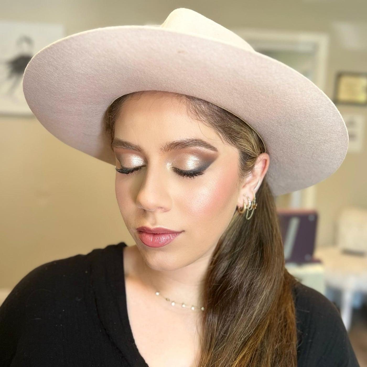 Client in a wide-brim hat with a brown smoky eye and a pink lip